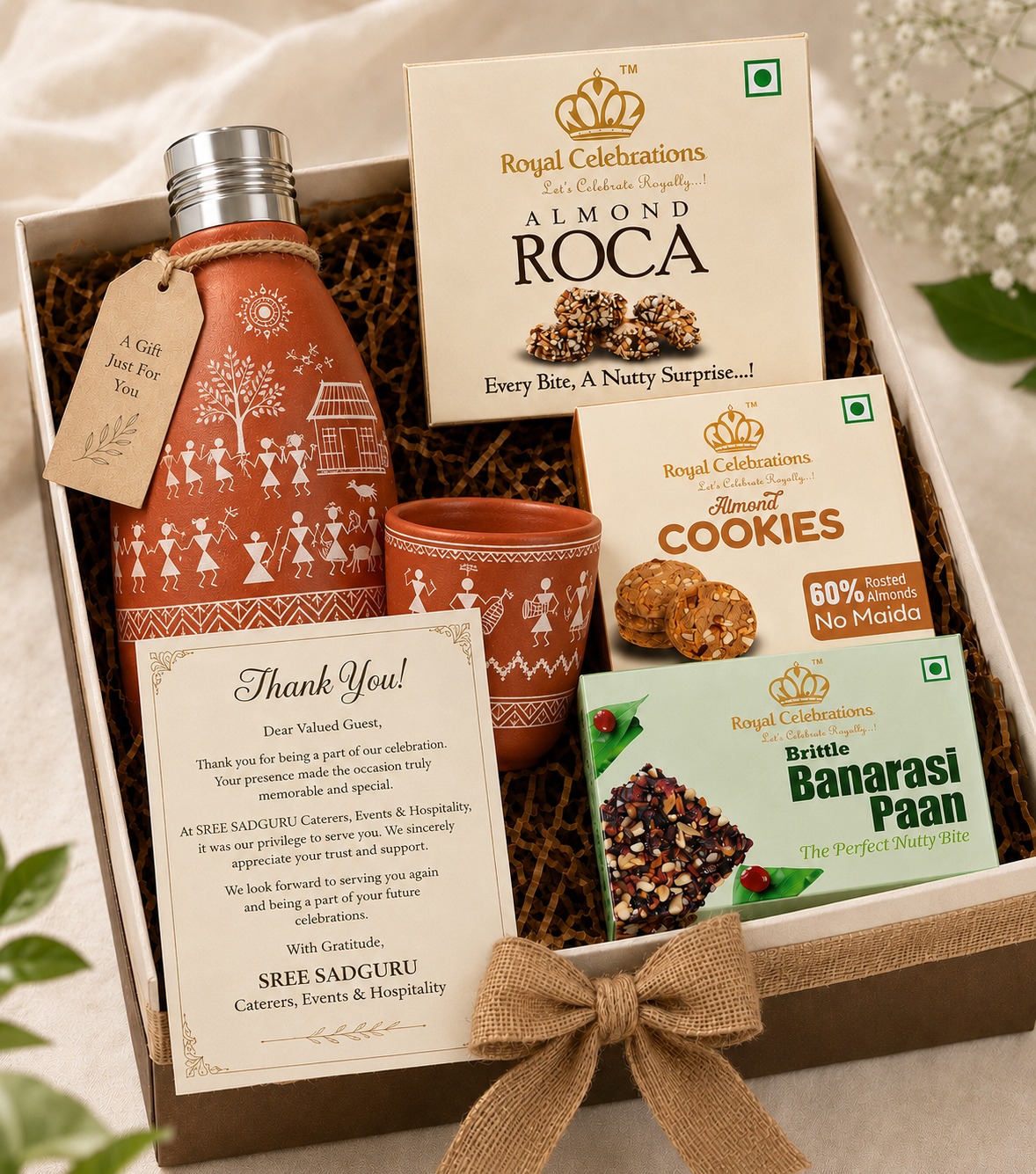 Eco friendly terracotta Warli bottle return gift hamper with almond roca and Banarasi paan